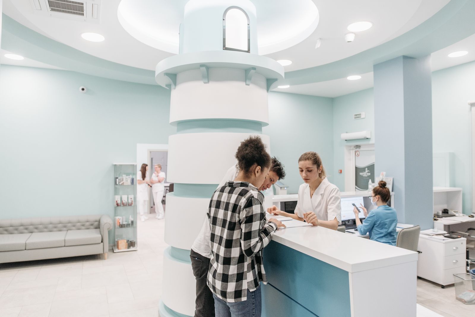 Patients registering at a bright, welcoming dental clinic reception desk