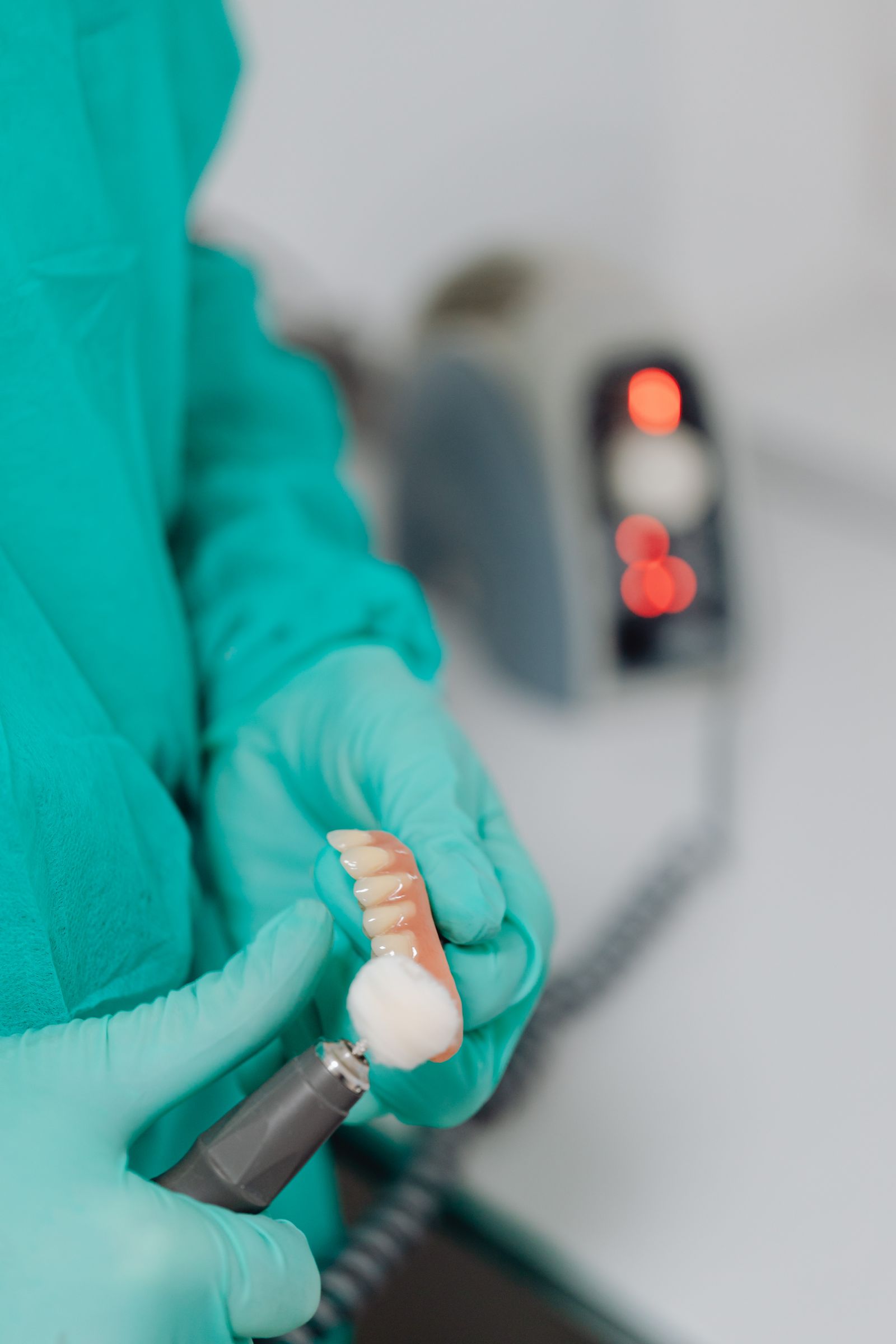 A dental professional polishing a partial denture appliance